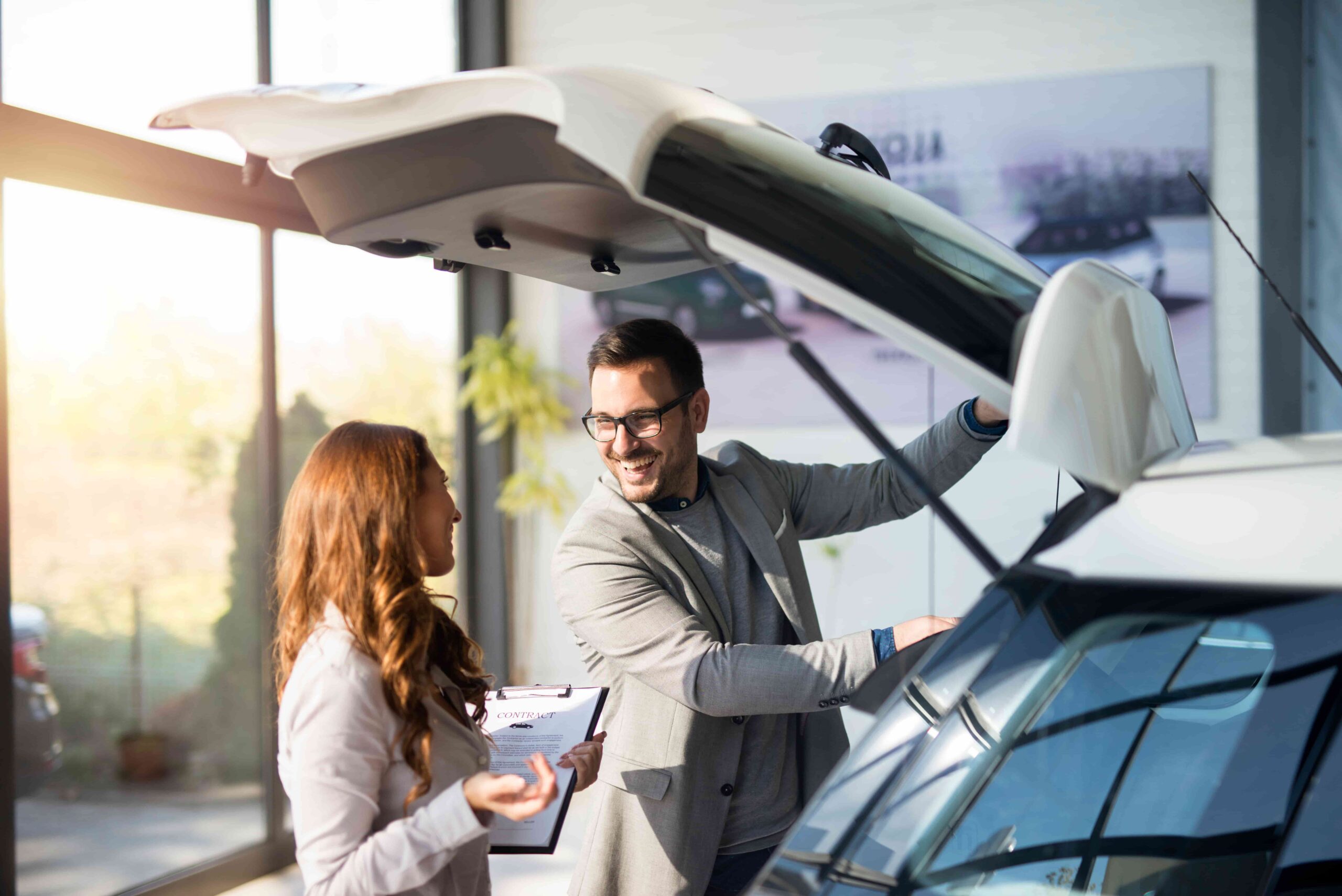 Um homem fica feliz com o carro que adquiriu no consórcio de carros usados.